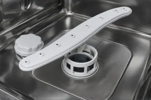 a dishwasher interior showing spray arm, filter, and stainless steel drain